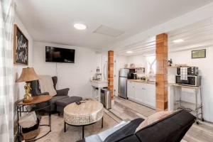 a living room with a couch and a kitchen at Brews, Bites, & Pines - Your downtown Flagstaff suite in Flagstaff