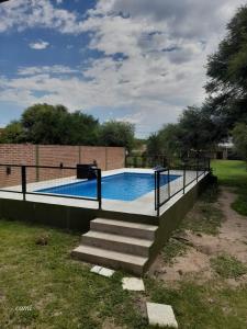 a swimming pool with stairs next to a fence at Casa Camila in Villa Cura Brochero