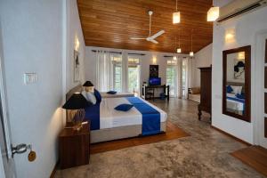 a bedroom with a bed with blue and white sheets at Forest Edge Resort in Kitulgala +37 photos