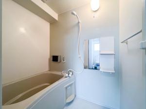 a bath tub in a bathroom with a shower at Trioni EBISU なんば-心斎橋エリア in Osaka