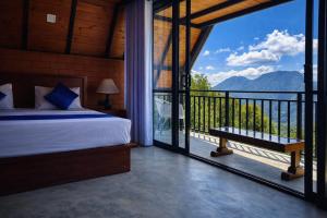 a bedroom with a bed and a balcony with a view at Forest Edge Resort in Kitulgala