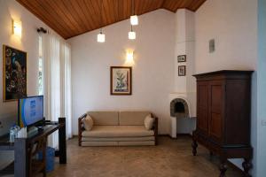 a living room with a couch and a table at Forest Edge Resort in Kitulgala