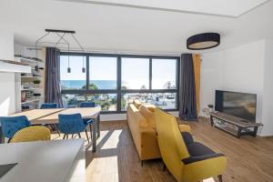 a living room with a table and chairs and a large window at Waterfront Seaview Residence in Villajoyosa