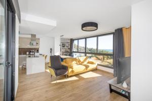a living room with a yellow couch and a television at Waterfront Seaview Residence in Villajoyosa
