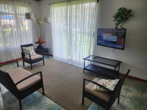 a living room with chairs and a flat screen tv at Casa de Campo Arenal in San Francisco