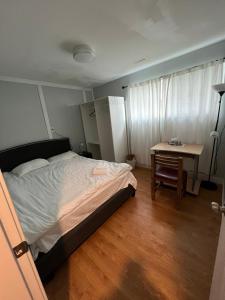 a bedroom with a bed and a desk and a table at Brentwood Home in Burnaby