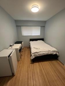 a room with a bed and two desks in it at Brentwood Home in Burnaby