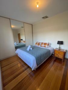 a bedroom with a large bed and a night stand at House on Heron in Mildura