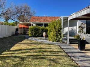 a house with a pathway in front of a yard at House on Heron in Mildura +3 photos