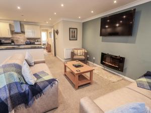 a living room with a couch and a table and a tv at Lakeland Loft in Windermere