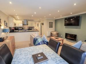 a living room with a dining table and a kitchen at Lakeland Loft in Windermere