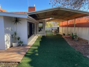 a covered porch of a house with green grass at House on Heron in Mildura