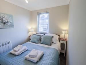 a bedroom with a bed with towels on it at Lakeland Loft in Windermere