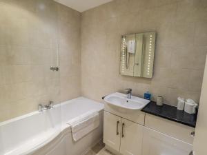 a bathroom with a sink and a bath tub and a sink at Lakeland Loft in Windermere +15 photos