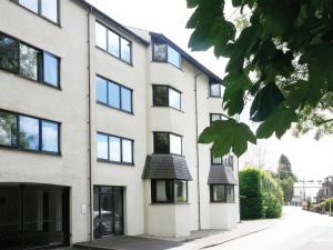 a white building with black windows on a street at Lakeland Loft in Windermere