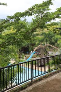 a pool in a park with a fallen tree at Meg's Resort in Andoon