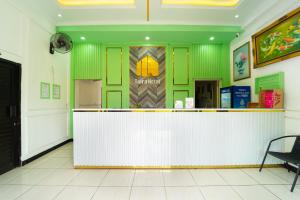 a restaurant with a white counter and green walls at Hotel Tiara By ARBA in Weleri