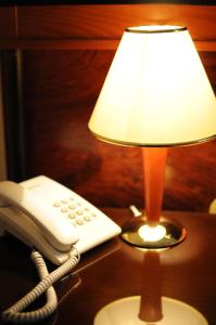 a phone sitting on a table next to a lamp at Millenium Palace in Ohrid
