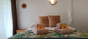 a bedroom with a bed with towels on it at Kuhane Etno-Hostal in Hanga Roa