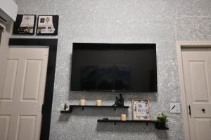ein Wohnzimmer mit einem Flachbildfernseher an der Wand in der Unterkunft Tiny Space, Big Comfort in Tampa