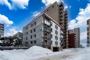 an apartment building with snow in front of it at Zabo Hills 203 in Sapporo