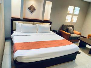 a hotel room with a large bed and a chair at Roxas Midtown Hotel in Roxas City +18 photos