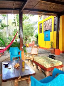 a patio with a couch and a table and chairs at Yellow Submarine Hostal in Poneloya
