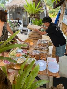 a man standing at a table with food on it at La Bohème in Gili Islands