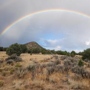 a rainbow in the sky over a field at The Elevated Retreat in Cedar City