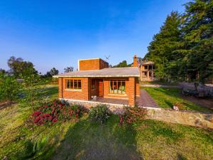 a small brick house on a grassy hill at Cabañas villa de San Miguel in Huasca de Ocampo