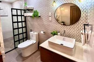 a bathroom with a sink and a toilet and a mirror at Hotel P INC General Santos in General Santos +30 photos