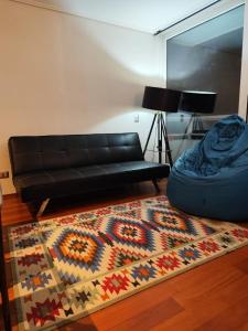 a living room with a couch and a rug at Valparaiso01 in Valparaíso