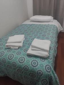 a bed with white towels on top of it at Valparaiso01 in Valparaíso