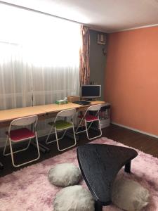 a room with a desk with a computer and chairs at Cozy Penguin House Bibai in Bibai