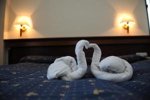 two towel swans making a heart on a bed at Millenium Palace in Ohrid