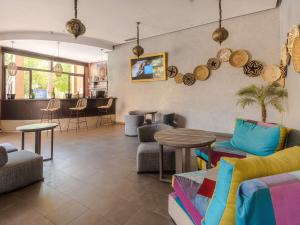 a lobby with chairs and tables and a bar at Novotel Marrakech Hivernage in Marrakesh