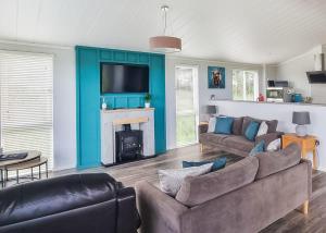 a living room with a couch and a fireplace at Woodlands Park Lodges At Haystax in Knitsley