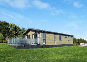 a house with a deck on a grass field at Woodlands Park Lodges At Haystax in Knitsley