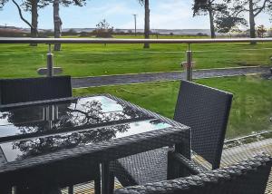 a table and chairs on a patio with a view of a park at Woodlands Park Lodges At Haystax in Knitsley
