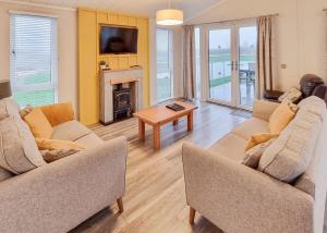a living room with two couches and a fireplace at Woodlands Park Lodges At Haystax in Knitsley +27 photos