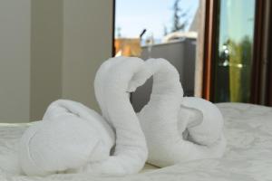 two rolls of white towels sitting on a bed at Millenium Palace in Ohrid