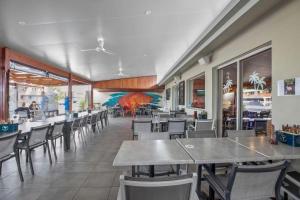 a dining room with tables and chairs in a restaurant at Sarina Beach Motel in Sarina