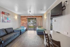 a living room with a couch and a table at Sarina Beach Motel in Sarina