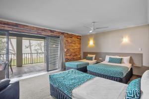 a bedroom with two beds and a balcony at Sarina Beach Motel in Sarina +92 photos