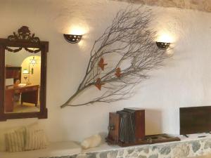 a painting of a tree branch on a wall at AFOURA HOUSES by K&K in Pyrgos