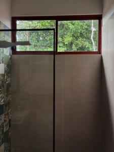 a bathroom with a glass door with a window at Villa Monarca - Markinkia Estancia Amazónica in Macas +4 photos