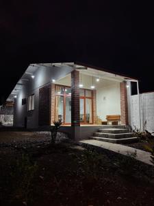a house lit up at night with lights at Villa Monarca - Markinkia Estancia Amazónica in Macas