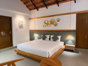 a bedroom with a white bed and a table at Bhoomi by Ostello in Varkala