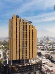 a tall yellow building in the middle of a city at Departamento en Torre Historicah in Monterrey
