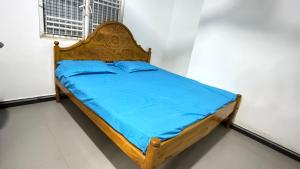 a bed with a wooden frame in a room at Nikshi Guest House in Nikawatawana